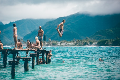 man diving from dock with people