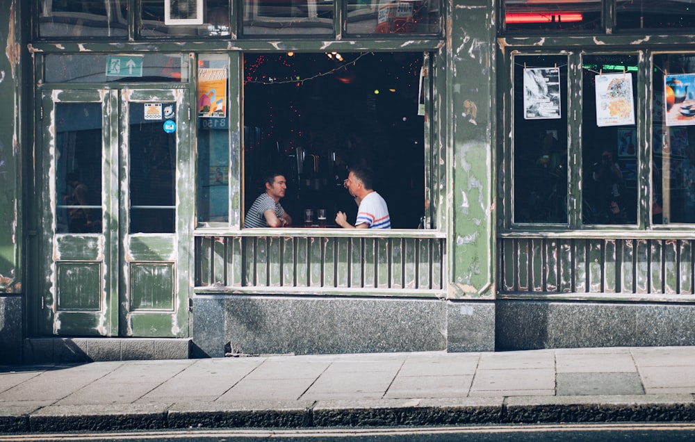 deux personnes discutant à l’intérieur du bar pendant la journée