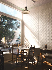 Sunlit café interior with customers enjoying their meals and coffee.