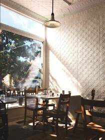 Sunlit café interior with customers enjoying their meals and coffee.