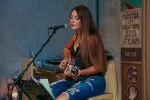 woman playing guitar while singing