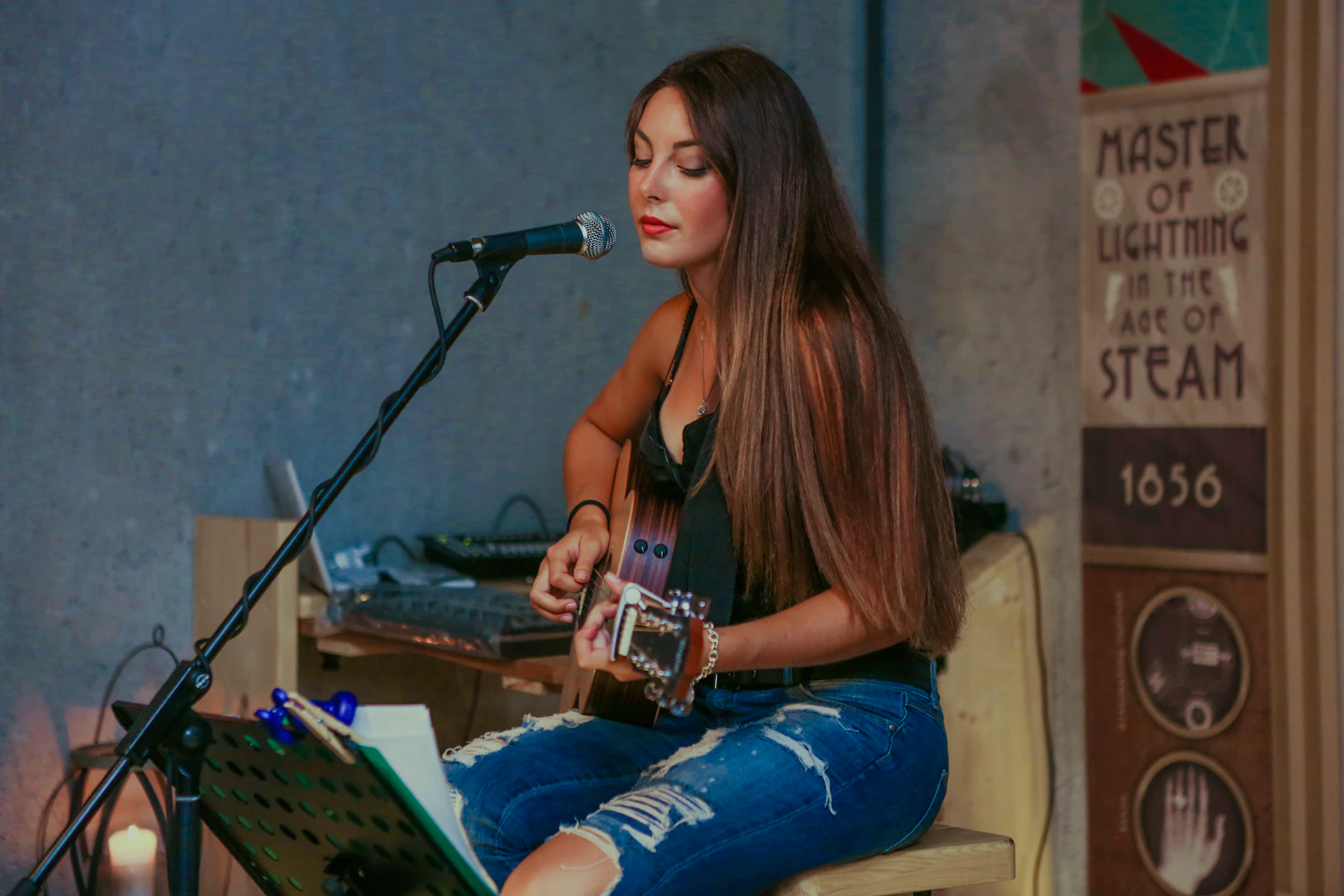 A student singing while playing acoustic guitar