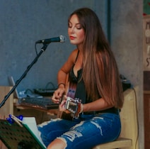 woman playing guitar while singing