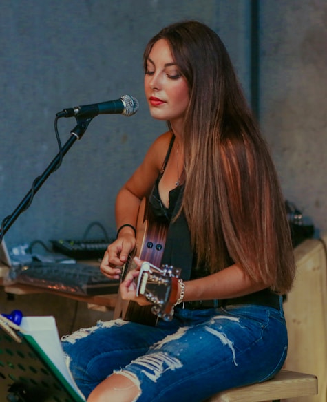 woman playing guitar while singing