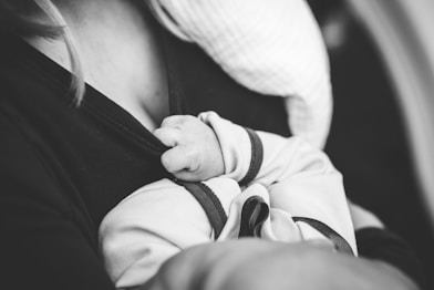 grayscale photo of woman carrying a baby