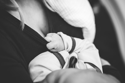 grayscale photo of woman carrying a baby