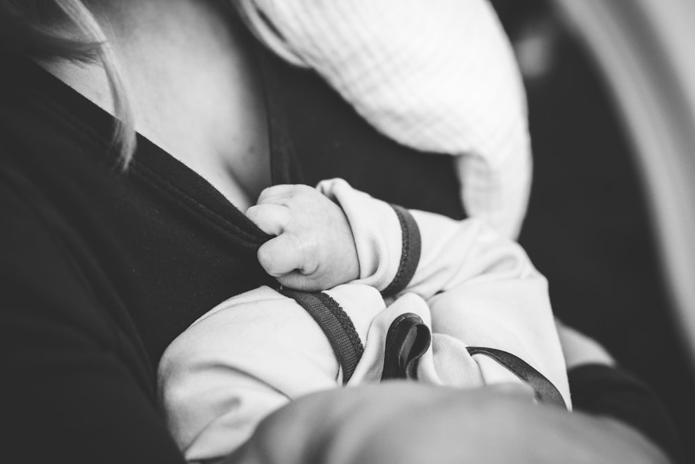 Foto en escala de grises de una mujer que lleva un bebé