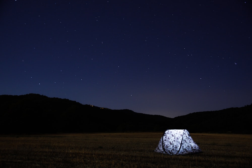 photography of lighted tent on field