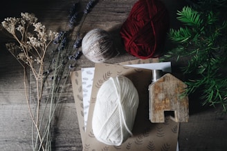 brown, white, and red yarn near flowers