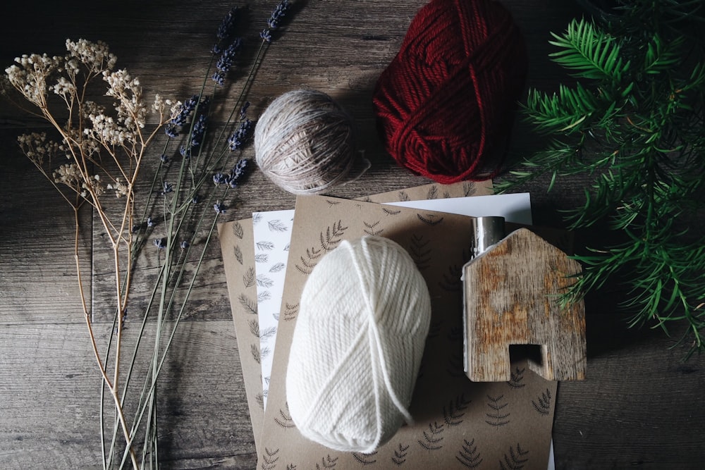 brown, white, and red yarn near flowers