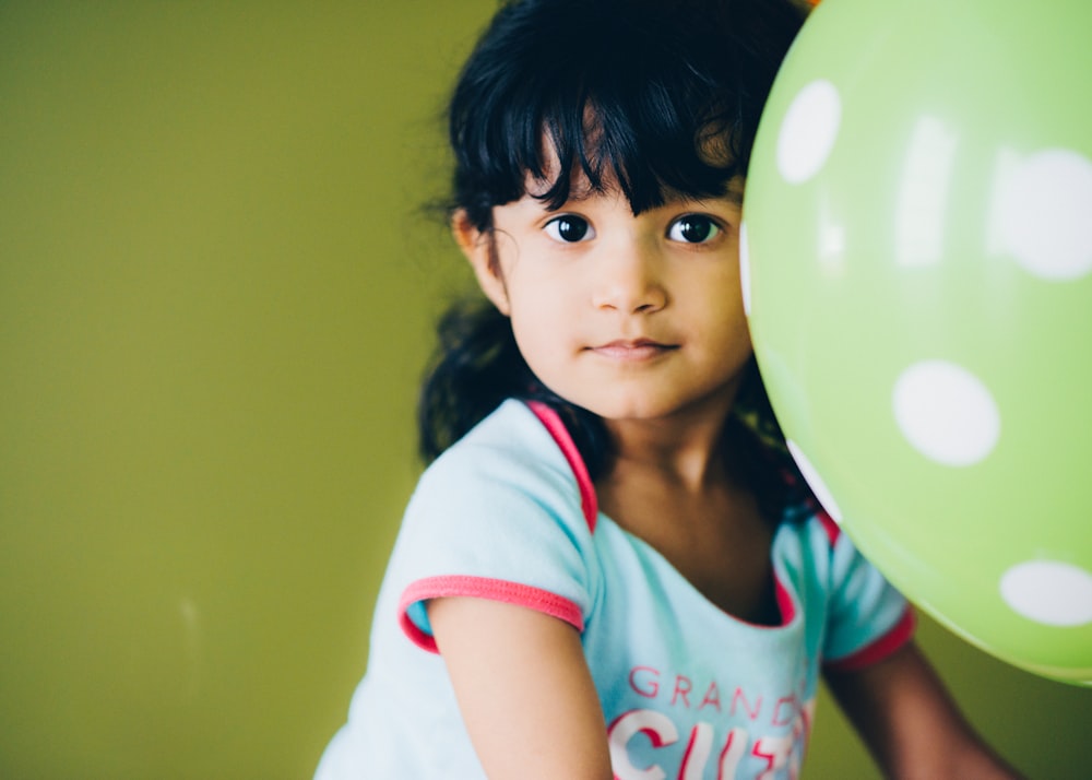 girl holding green balloon