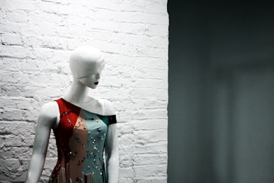 A close-up of a fashionable dress hanging on a mannequin with soft lighting.