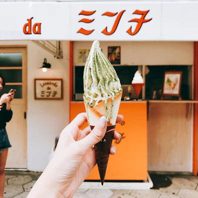 Happy customers holding pastel-colored ice cream cones in front of the Dulce Frío shop