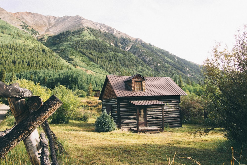 Casa de madeira marrom perto das montanhas durante o dia