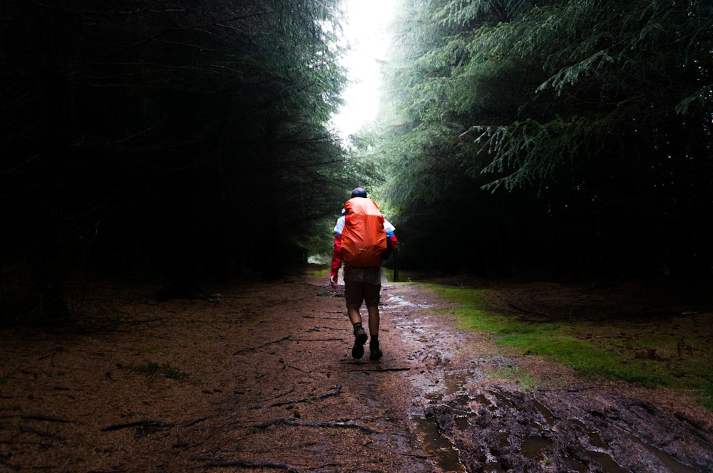 man with red bag in the middle of forest