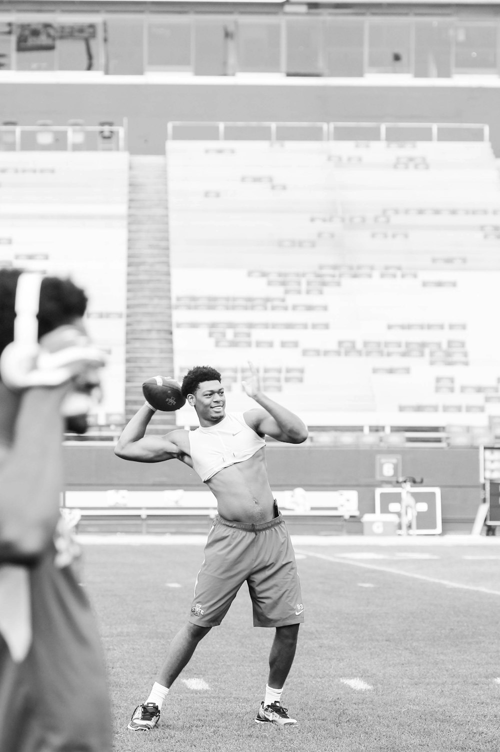 grayscale photo of man playing football