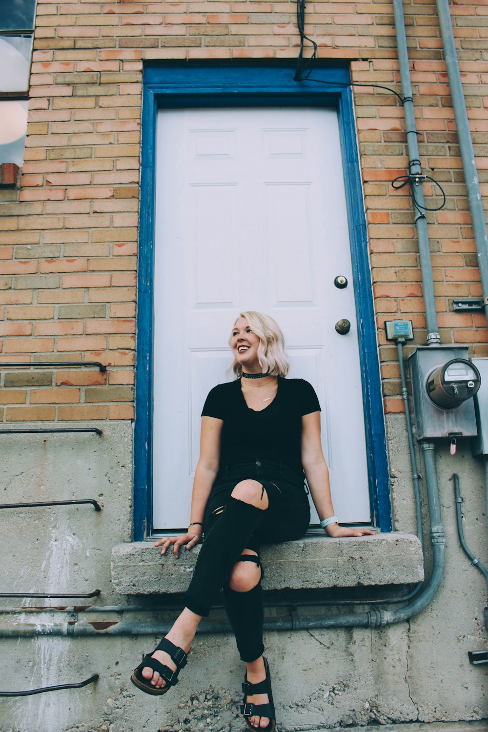 woman in black shirt sitting on concrete floor