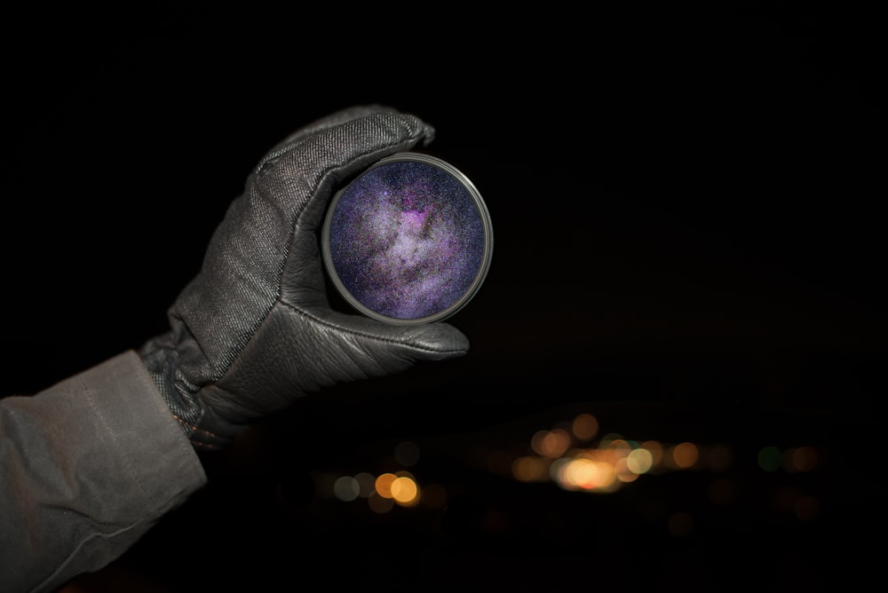 person holding round purple case