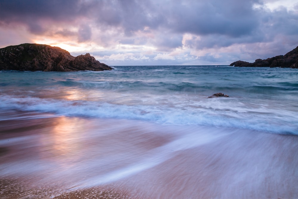 landscape photography of rock formations and body of water