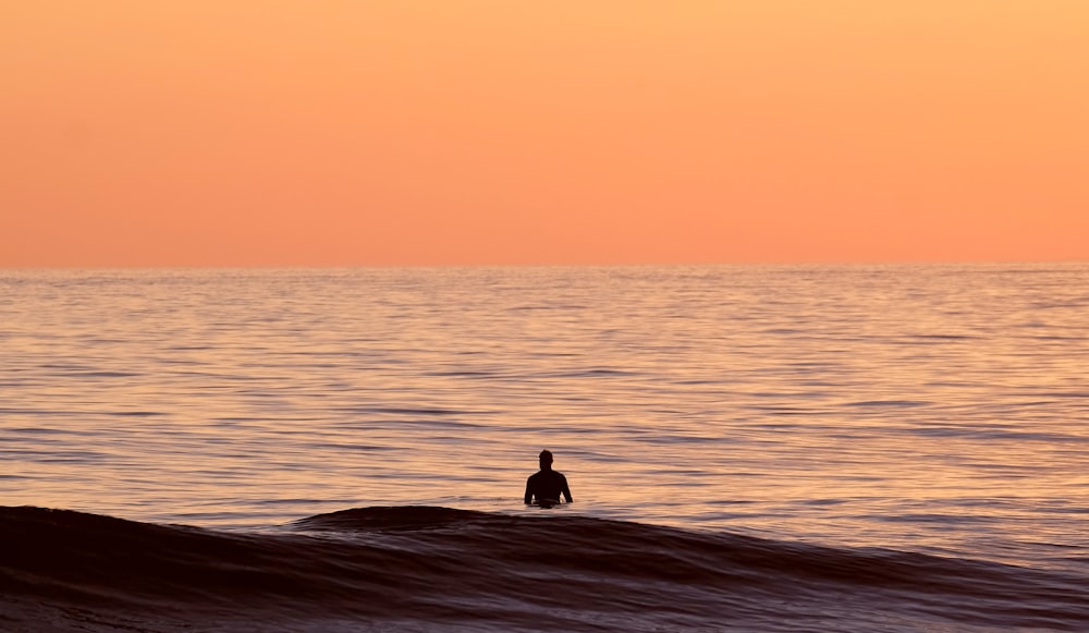 silhouette of person in body of water