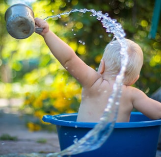 child lifting water dipper