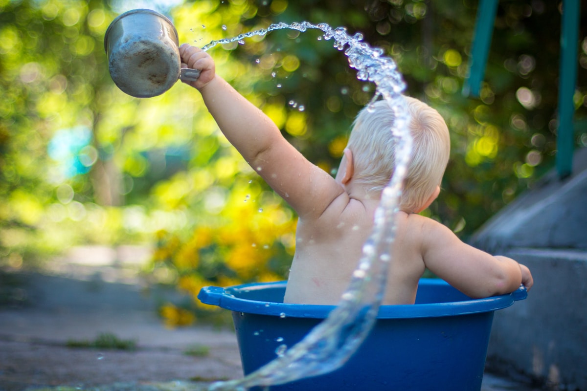 baby bathing in a washing up tub