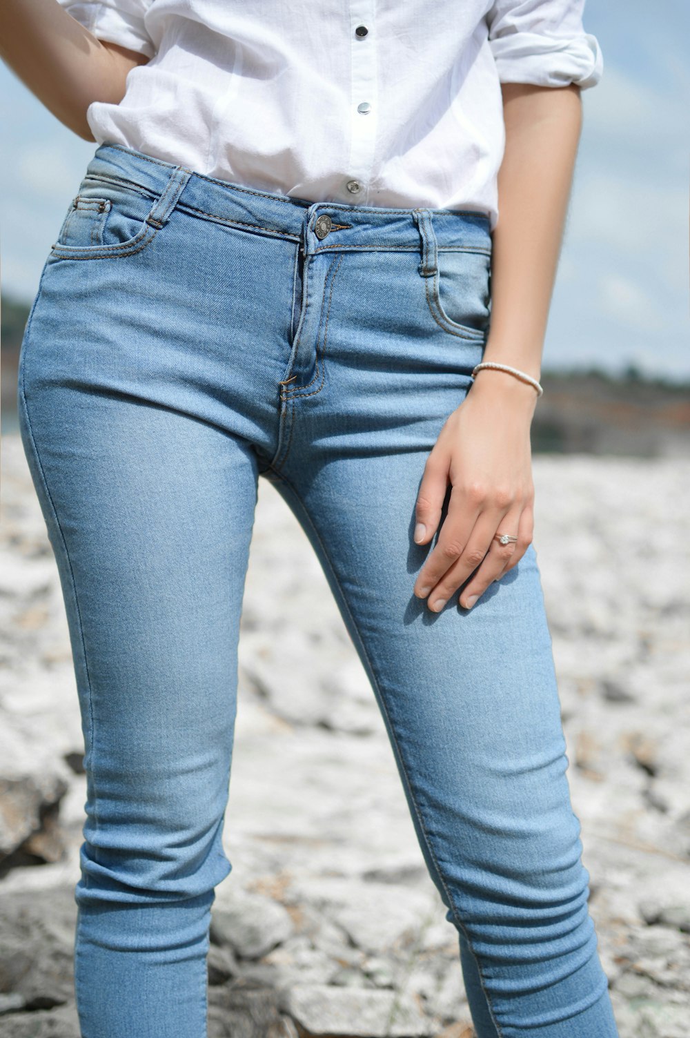 woman standing wearing jeans and white top