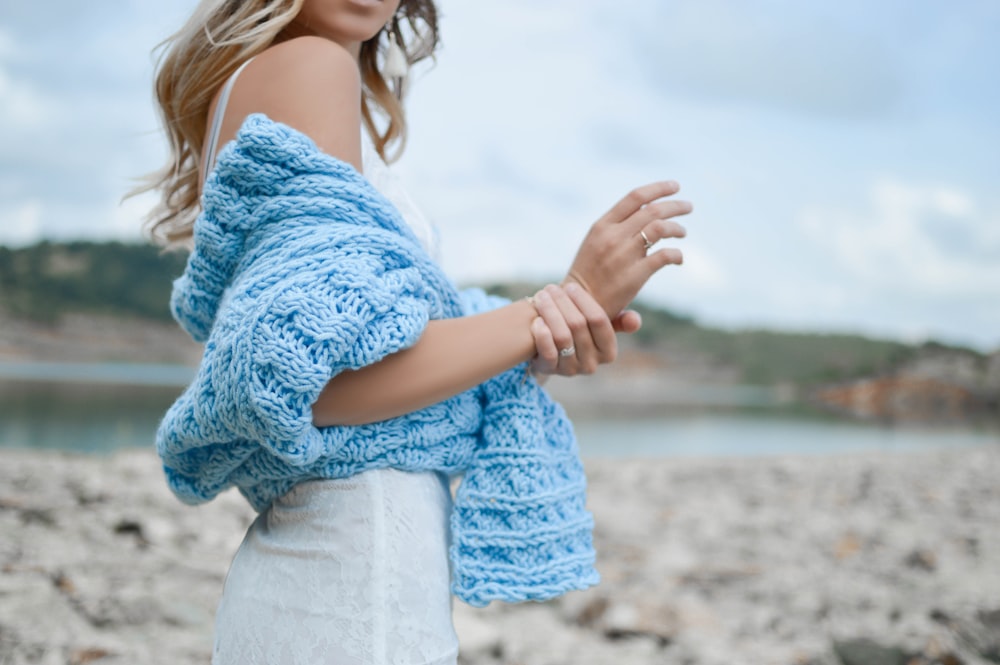 woman wearing teal crochet top and white skirt