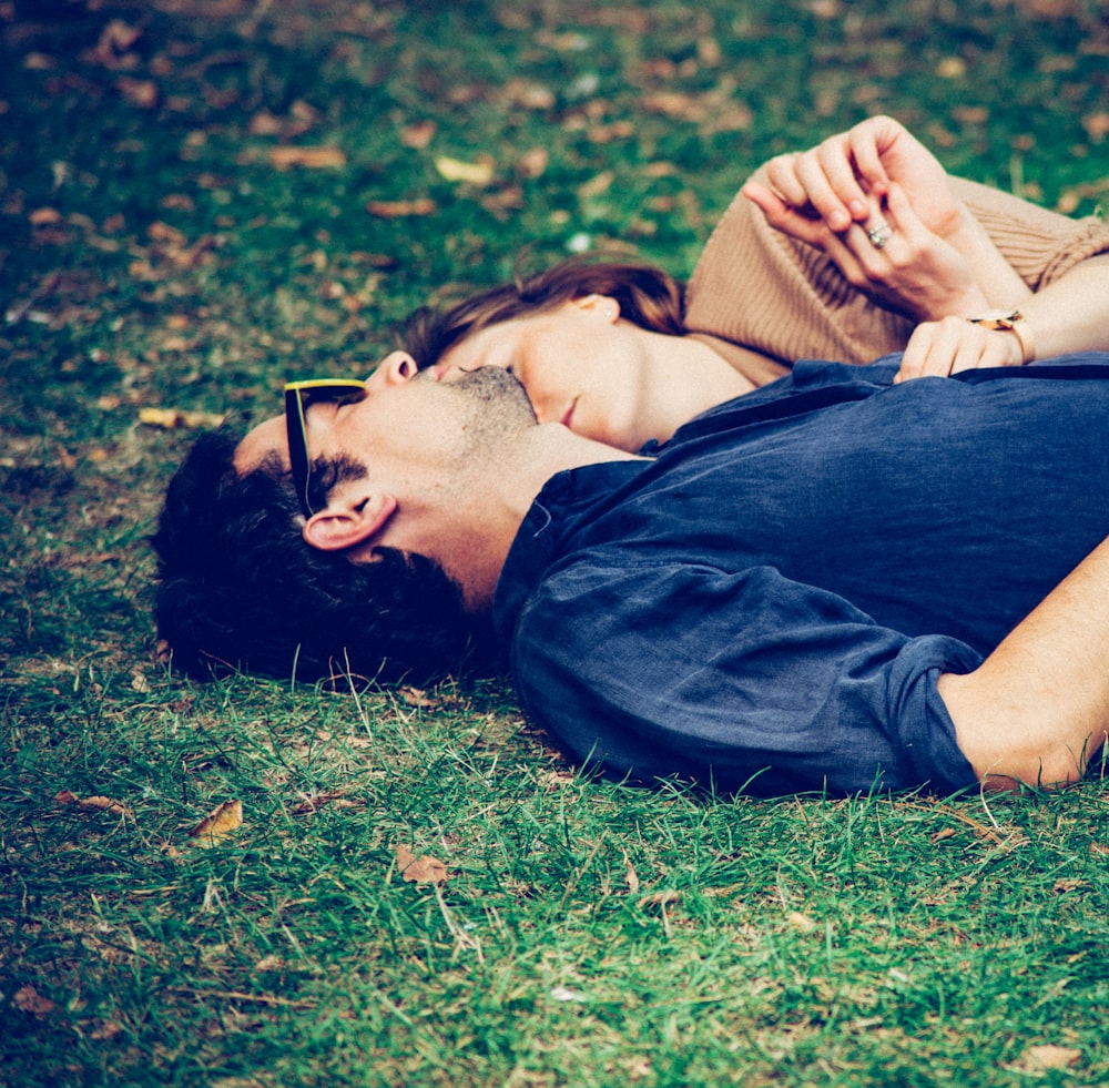 man and woman lying on grass