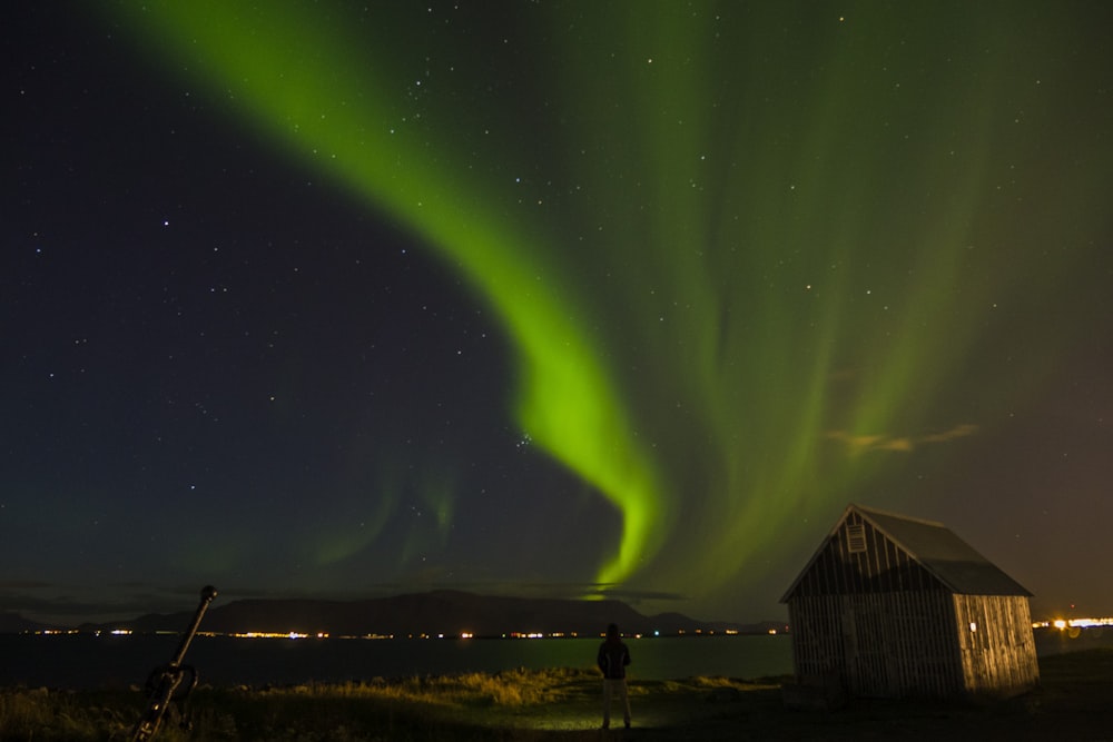 landscape photography of house near body of water with aurora