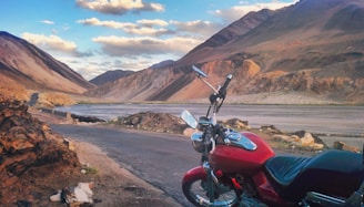 A scenic view of mountains with a motorcycle parked in the foreground.