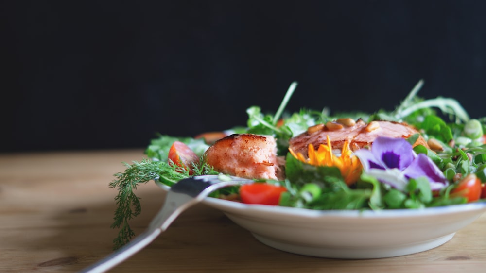 serving of salad and fish on white plate