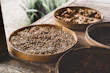A basket filled with fresh grains, pulses, and natural ingredients on a kitchen counter.