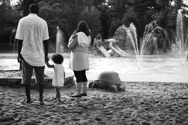 A warm, friendly photo of diverse single parents and their children enjoying a sunny park in Toronto.
