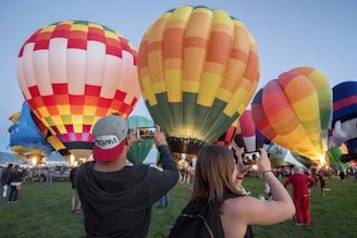 Close-up of colorful hot air balloons preparing for takeoff with excited travelers.