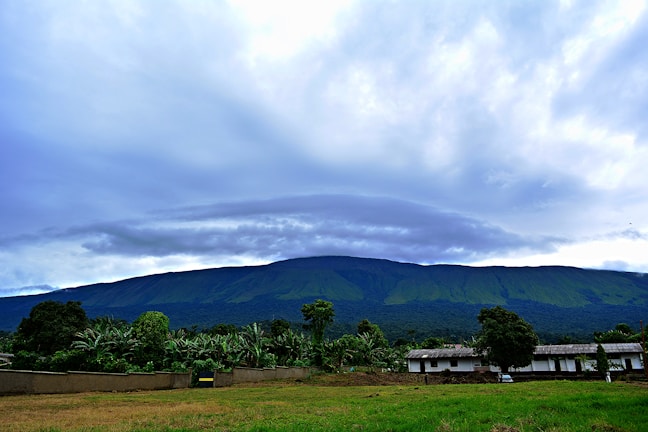 A wide-angle shot of a mountain range under a dramatic cloudy sky.