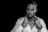 grayscale portrait of man wearing white dress shirt on black background
