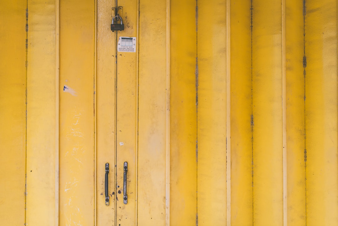 closed yellow wooden door with padlock