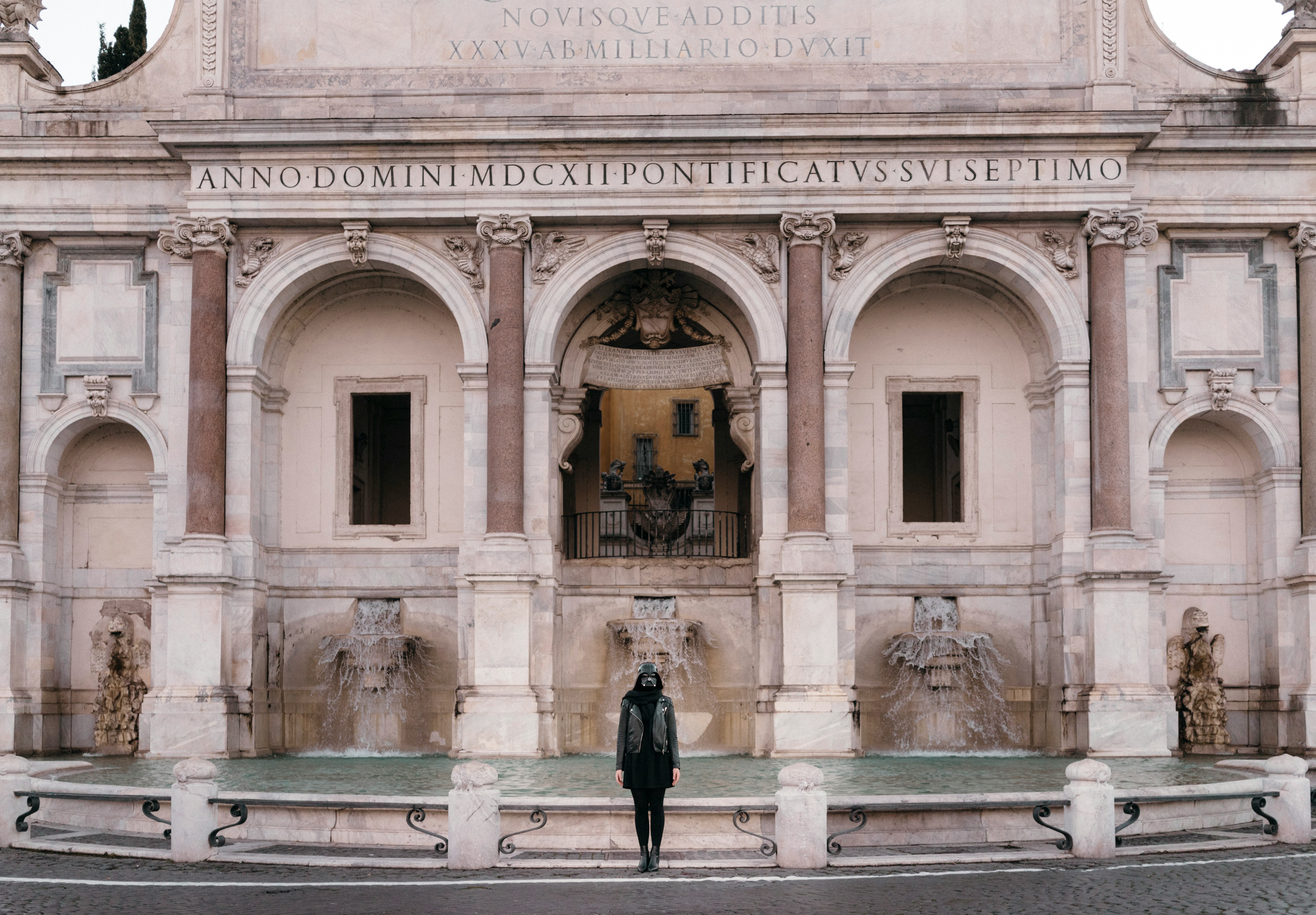 person standing in front of outdoor fountain during daytime