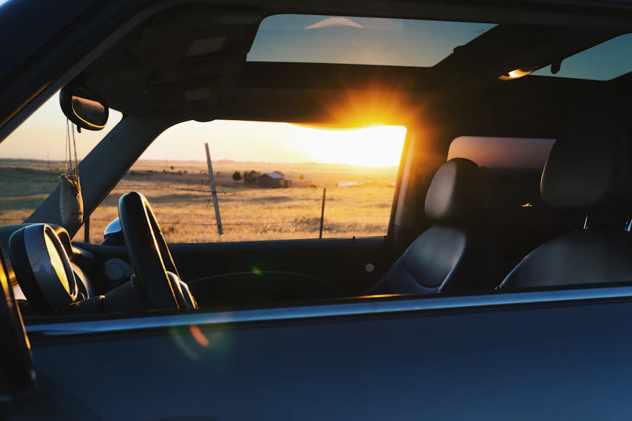 Sunset seen through the open sunroof and side glass of a parked vehicle