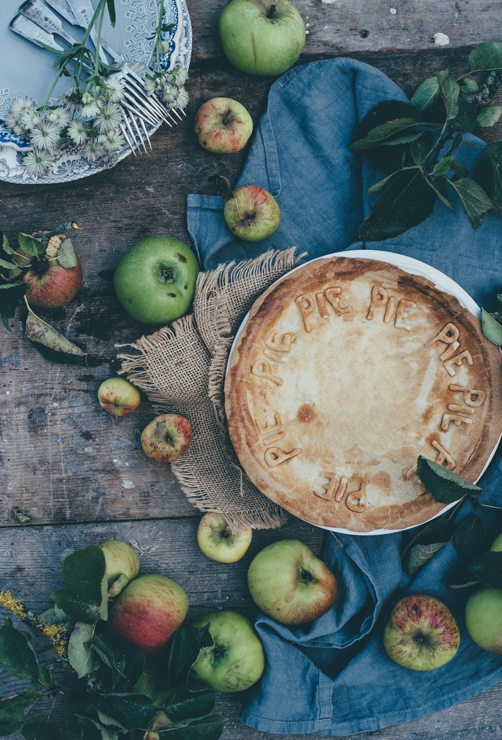 baked pie beside green apples