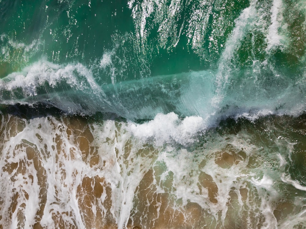 Fotografia aerea delle onde del mare in riva al mare durante il giorno