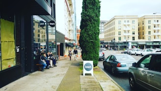 Street view of a busy commercial area with shops and cafes.