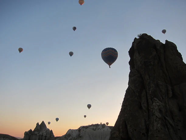 Hot air balloons floating gently over the Luxor landscape at dawn.