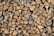 A stack of neatly arranged chopped firewood, featuring pieces of varying sizes and shapes, with visible textures and tree rings.