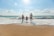 man, woman and child holding hands on seashore