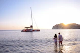 Couple watching the sunset from a boat drifting near Cozumel coastline.
