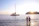 A happy couple enjoying a luxurious yacht deck with the sunset over the Aegean Sea in the background.