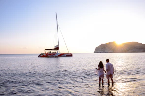 Couple watching the sunset from a boat drifting near Cozumel coastline.