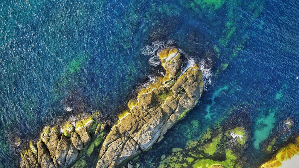 aerial view photography of rock formations surrounded by ocean during daytime